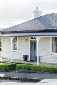 uma casa branca com uma porta azul em Galvin Town Cottage, convenient to CBD em Kings Park