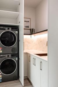 a kitchen with a washer and dryer in a room at Large Apartment in Launceston- Timeless Luxury in Launceston