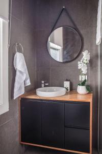 uma casa de banho com um lavatório e um espelho em Mulgrave Street Cottage- renovated comfort em Kings Park