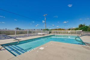 una piscina con una valla blanca y un cielo azul en Unit 102D at Tiffany's, en Surf City