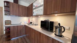 eine Küche mit einer Mikrowelle und einer Kaffeemaschine auf der Theke in der Unterkunft RIGA street Apartments 54 in Valmiera