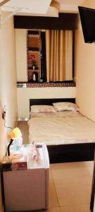 a bedroom with a bed and a table with a night stand at AMAZING Couples private room close to Mall of Emirates in Dubai