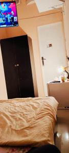 - une chambre avec un lit doté d'une porte noire et d'une télévision dans l'établissement AMAZING Couples private room close to Mall of Emirates, à Dubaï