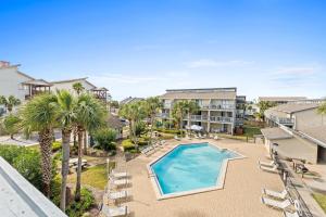 una vista aérea de una piscina con sillas y palmeras en Sunswept by Panhandle Getaways, en Panama City Beach