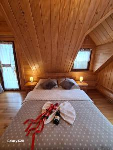 een slaapkamer met een bed in een houten plafond bij Miodowa Chata in Brenna
