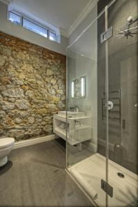 Cape Town的住宿－三號精品酒店，一间带玻璃淋浴和卫生间的浴室