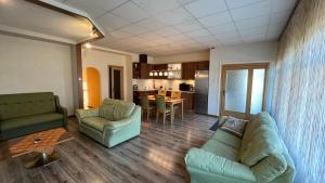 ein Wohnzimmer mit einem Sofa, Stühlen und einem Tisch in der Unterkunft RIGA street Apartments 54 in Valmiera