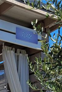 a sign that reads place on a shelf with a plant at Mobile Home PLAGE in Drage