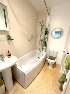 a bathroom with a tub and a sink and a toilet at Seabreeze Apartment in Eastbourne