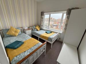 a small bedroom with two beds and a window at Seabreeze Apartment in Eastbourne