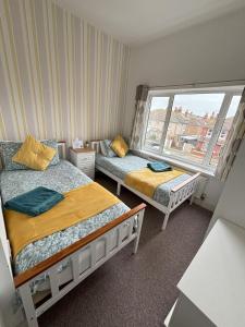 a small bedroom with two beds and a window at Seabreeze Apartment in Eastbourne