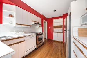 a kitchen with red walls and white cabinets at Tranquil Haven near Attractions 2BD Upper Floor or 2BD Basement Floor in Vancouver