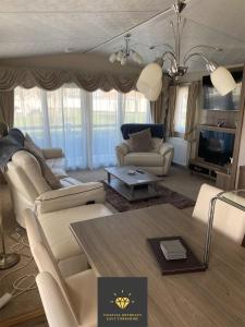a living room with a couch and a table at 2 Bed, 2 Bath Lodge Style Caravan with Hot Tub & Private Garden in Patrington