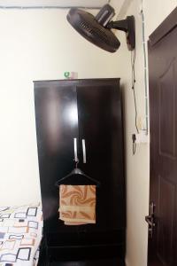 a black refrigerator in a room with a light at Smilley's Place Roffi in Lagos