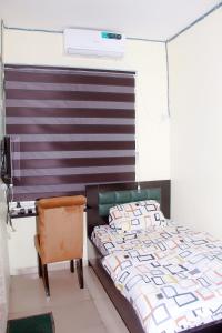 a bedroom with a bed and a chair at Smilley's Place Roffi in Lagos