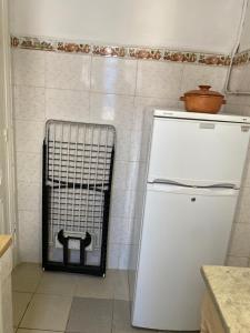 einen weißen Kühlschrank in einer Küche mit Fliesenboden in der Unterkunft Tunis Lafayette in Tunis