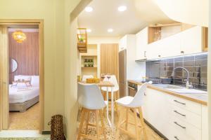 a kitchen with white chairs and a table and a bed at New Renovated Apt in City Center in Heraklio Town +16 photos