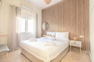 a bedroom with a large white bed and a window at New Renovated Apt in City Center in Heraklio Town