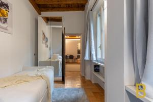 a bedroom with a bed and a hallway with a window at BePlace Apartments in Magenta in Milan