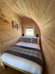 1 cama en una habitación pequeña en una cabaña de madera en Stoer Pods - Suilven Pod en Lochinver