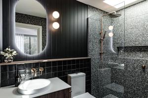 een badkamer met een wastafel, een douche en een spiegel bij Al Fresco Living apartment in Launceston in Launceston