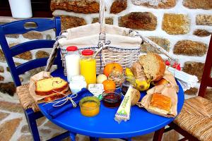 una mesa azul con una cesta de comida y pan en Άρνη (η κόρη του Αιόλου) en Arnaia