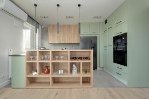a kitchen with green and white cabinets and a counter at Exclusive River View Apartment with Balcony & FREE GARAGE by Renters Prestige in Wrocław