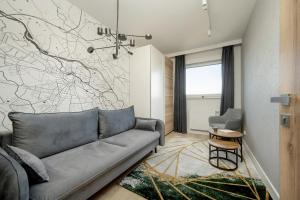 a living room with a couch and a wall mural at Exclusive River View Apartment with Balcony & FREE GARAGE by Renters Prestige in Wrocław