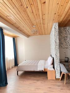 a bedroom with a bed and a wooden ceiling at Apart-Hotel Seti in Mestia