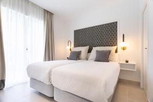 um quarto branco com uma grande cama branca e janelas em Genteel Home Ricardo Soriano em Marbella