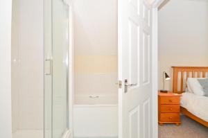 a bathroom with a shower and a glass door at 24 Tollgate Cottages in Seaview