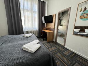 a hotel room with a bed with towels on it at Hotel Bregenz in Berlin