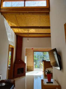 un soggiorno con una grande finestra e un camino di Casa Mohini a Teresópolis