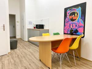 um escritório com uma mesa com cadeiras e um quadro em Pop Art Rooms em Praga