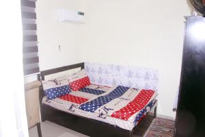 Una cama con almohadas rojas blancas y azules. en Smilley's Place Ms-Tammy, en Lagos