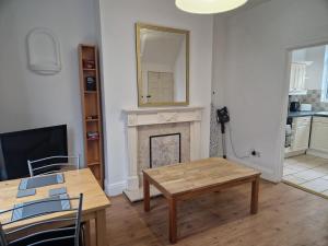 a living room with a table and a fireplace at Suite 1: Cosy Room in a Prime Location in Sheffield