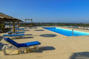 a swimming pool with lounge chairs next to a swimming pool at Monte Sardinha in Santiago do Cacém