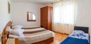 ein kleines Schlafzimmer mit 2 Betten und einem Spiegel in der Unterkunft Apartments in Lopar - Insel Rab 26467 in Lopar