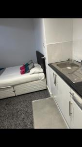 a small kitchen with a bed and a sink at Palatine Aparthotel in Liverpool