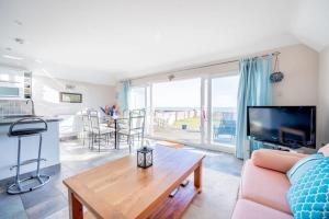 a living room with a couch and a table at Family Haven by the Waves Direct Beach Access in Pevensey