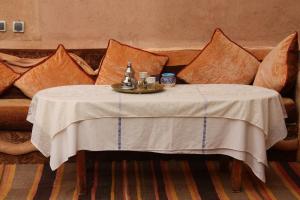 a couch with a table with a white table cloth at La perle de saghro in Nkob