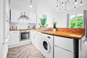 a white kitchen with a washer and dryer at Luxury Apartment - Parking - Wolverhampton 7aPC in Wolverhampton