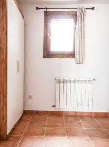 a room with a window and a tile floor at Hostal Antiguo Hospital in Linares de Mora