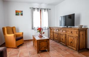 a living room with a flat screen tv and a chair at Hostal Antiguo Hospital in Linares de Mora