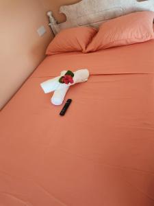 Rose Hideaway في فيو فورت: سرير مع ريموت كنترول و ورد عليه