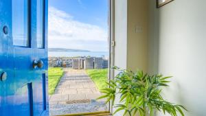 an open door with a view of the ocean at Moryn in Moelfre