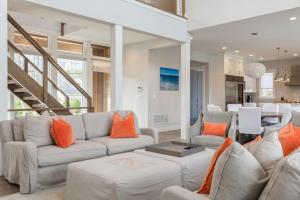 een woonkamer met witte meubels en oranje kussens bij Villa Kimaal - Luxury with pool in Sag Harbor