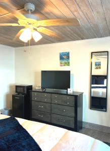 a bedroom with a ceiling fan and a dresser with a television at Exuma Palms Resort in Hermitage
