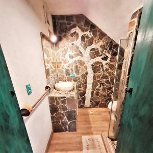 a bathroom with a stone wall with a sink at CHEVERE BEACH CABAÑAS SAS in Puebloviejo