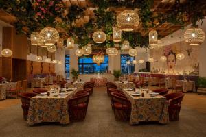 una sala da pranzo con tavoli, sedie e lampadari di Dreams Playa Mujeres Golf & Spa Resort - All Inclusive a Cancún